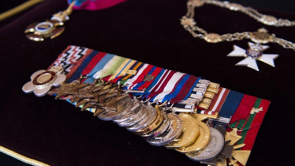 The Order of Merit, the Royal Victorian Chain and full size Medal Group, sewn onto a cushion