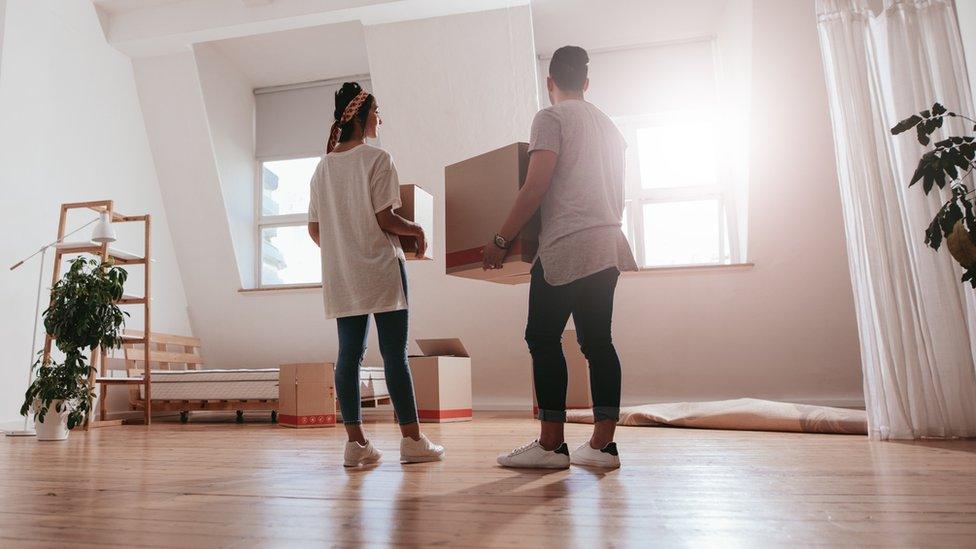 young couple carrying cardboard box