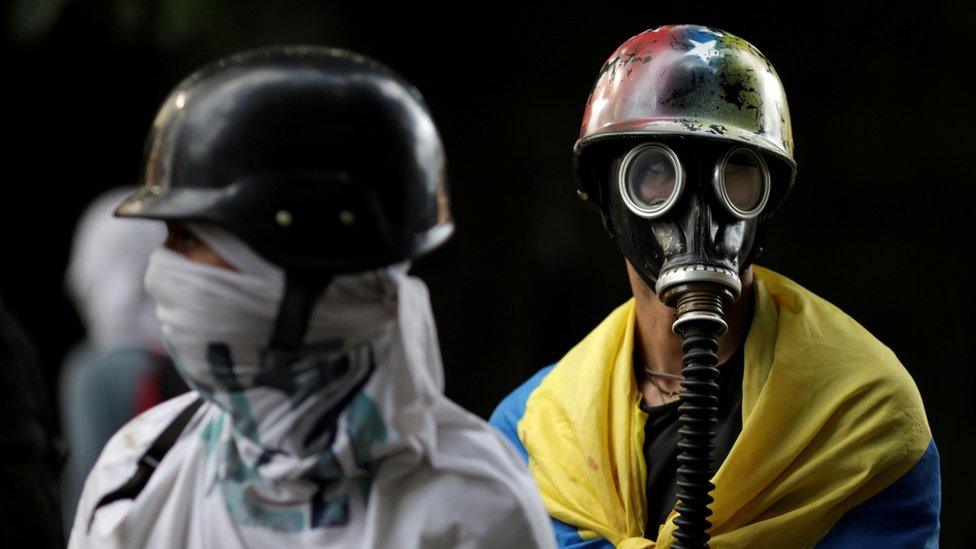 Demonstrators look on while rallying against the government in Caracas, Venezuela, 4 August