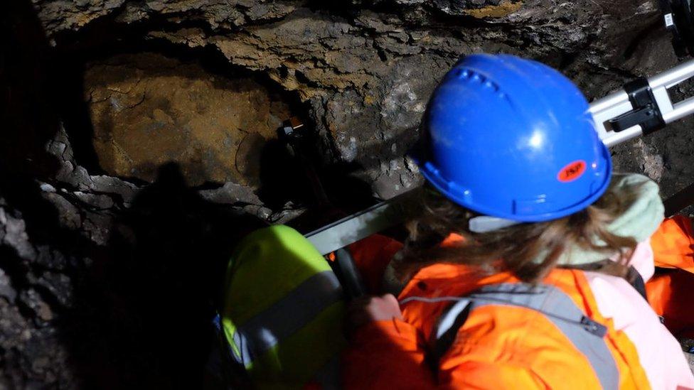 worker looks into hole