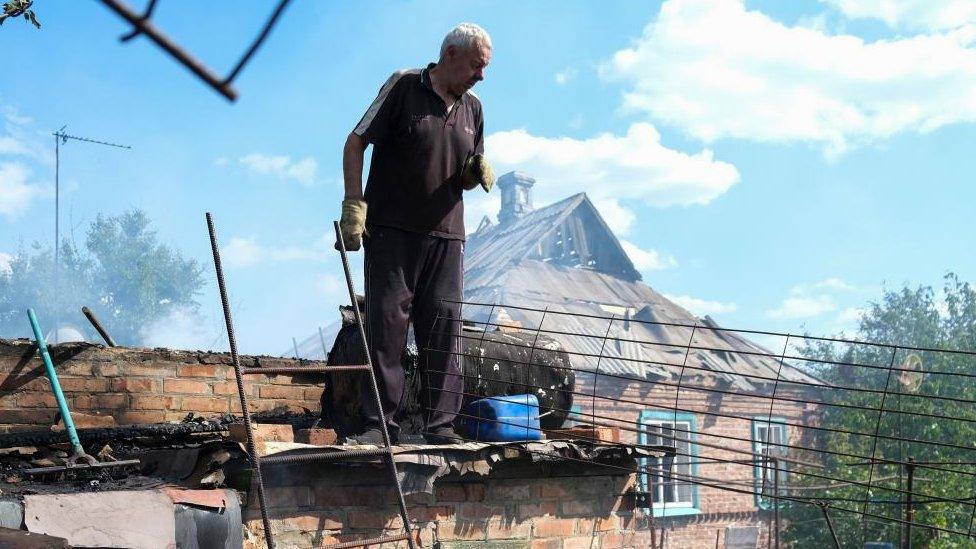 Locals react after the shelling of a private building in the small city of Bakhmut near the frontline in the Donetsk area