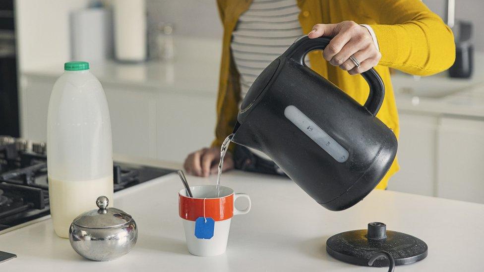 Woman using an electric kettle