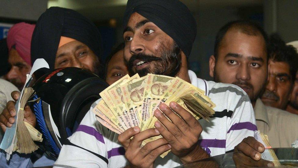 Indian bank customers wait to deposit 500 and 1,000 rupee notes at a bank in Amritsar on November 10, 2016