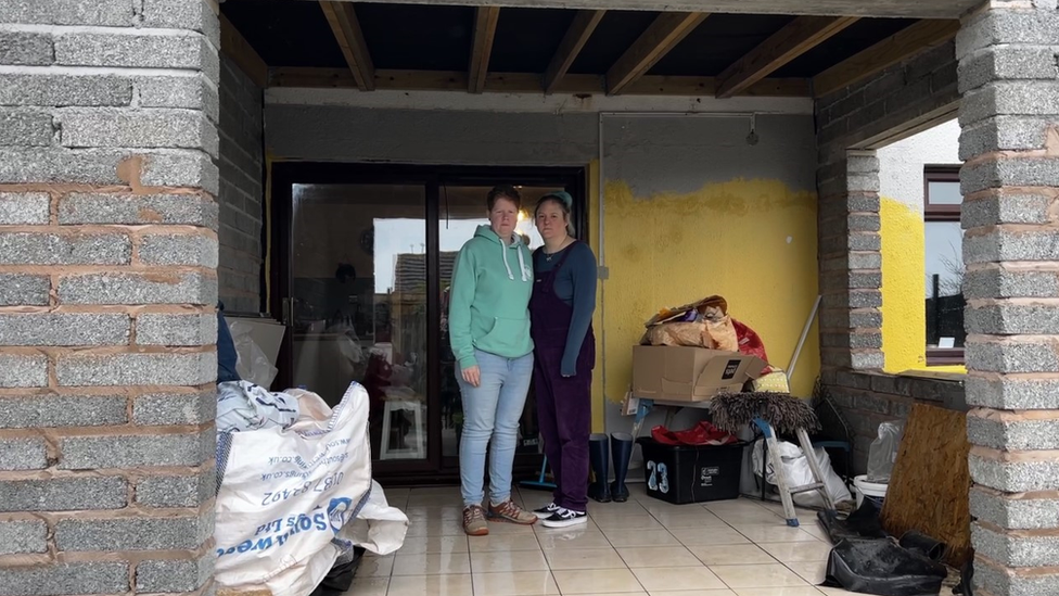 Caroline and Katie Aulsberry-Vockins stand in the building works at their house