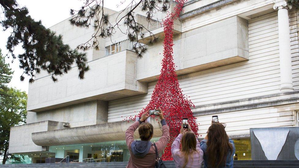 People take photos of the Weeping Window at the Ulster Museum