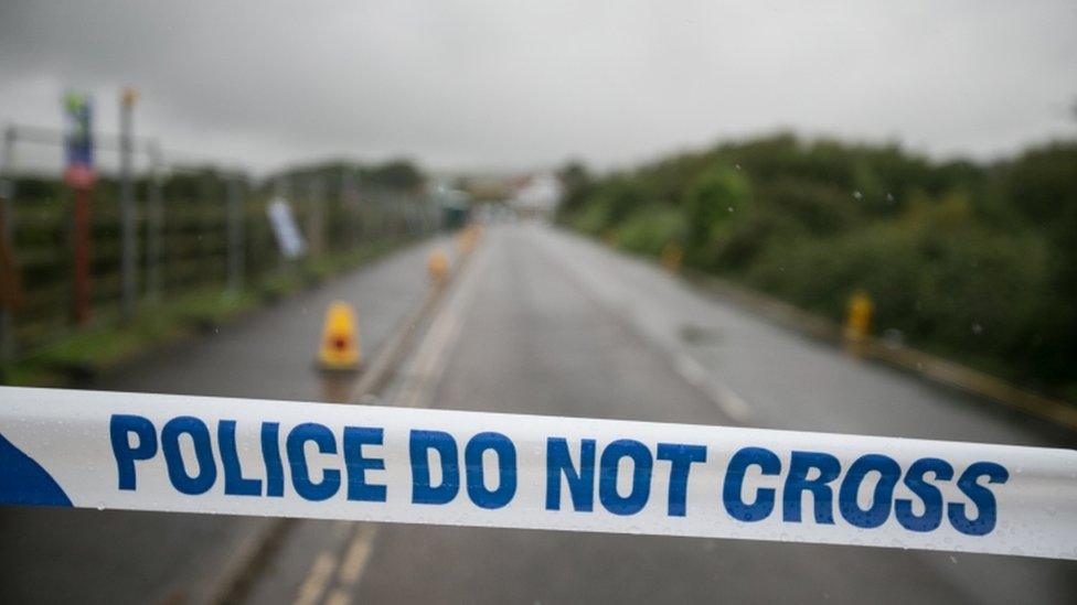 Police tape sealing off a road