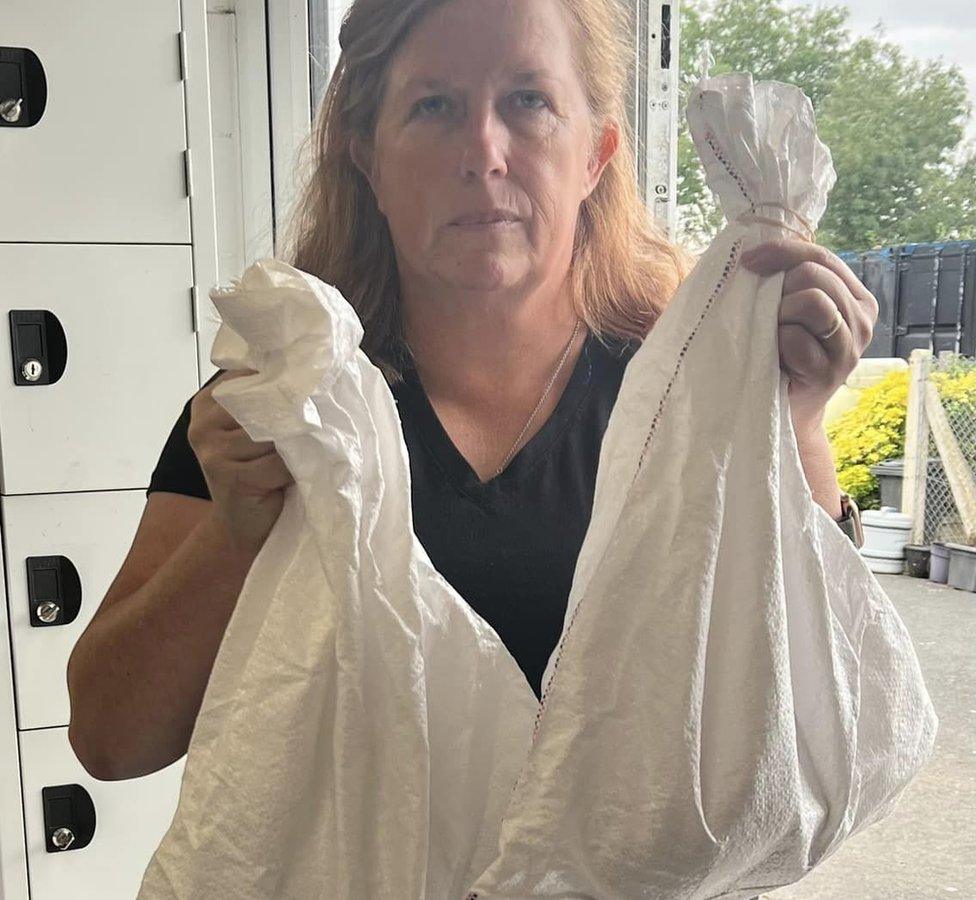 A lady holding the bags which contained the pythons