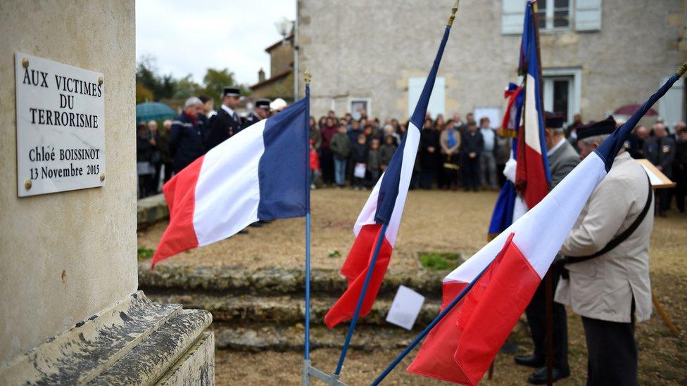 People gather during the unveiling of a plaque at the "monument aux morts " in memory of Chloe Boissinot, in Chateau-Larcher, central France, a victim of an attack on the Parisian restaurant "Le Petit Cambodge" one of several venues attacked by terrorists in Paris on November 13, 2015, as the French nation marks Armistice Day commemorations on November 11.