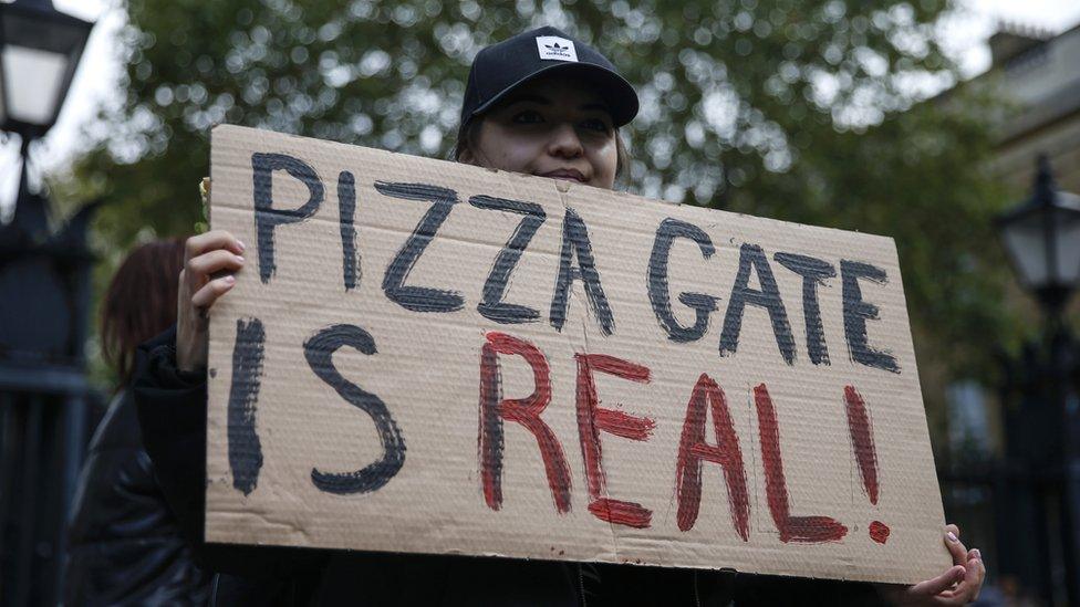 A protestor holds a sign during a "Save our Children" rally outside Downing Street on October 10, 2020 in London