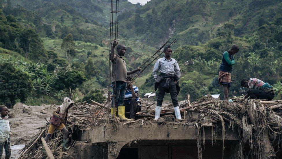 Residents of Nyamukubi stand amidst rubble after heavy flooding in eastern Democratic Republic of Congo, on May 6, 2023