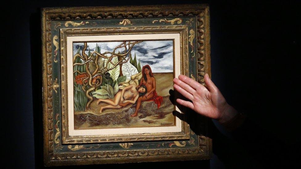 An Art specialist at Christie's speaks about the artwork 'Dos desnudos en el bosque (La Tierra Misma)' made by artist Frida Kahlo during a press preview on April 29, 2016, in New York.