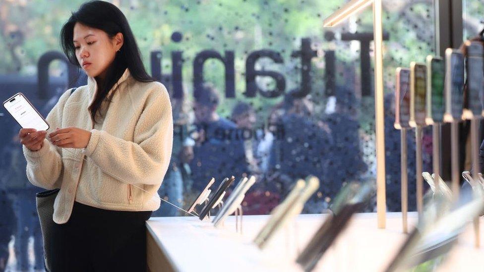 A customer views a new Apple iPhone 15 model on display in the Apple The Grove store on the phone’s worldwide release day on September 22, 2023 in Los Angeles, California.