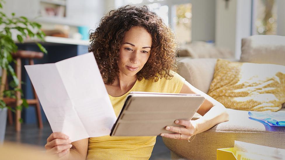 A person looks at contracts in living room