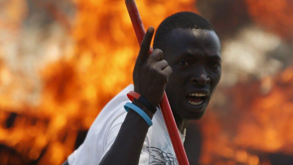 A protester gestures in front of flames in Burundi (2015 picture)