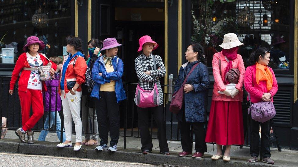 Tourists stand outside a pub in Edinburgh