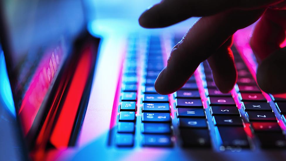 A person typing on a laptop keyboard