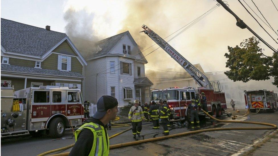 Firefighters at house with smoke coming out of it