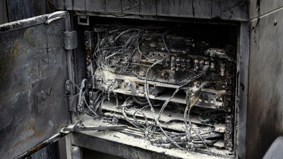 Damaged cabling and telecommunications equipment is pictured following a fire at a phone mast, attatched to the chimney at the converted Fearnleys Mill residential apartment block complex in Huddersfield, northern England, on April 17, 2020. -