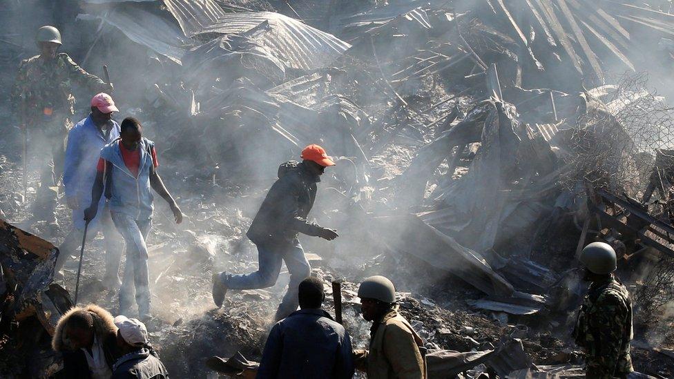 Riot police evict traders at the smouldering scene of fire that gutted Gikomba market, Nairobi, Kenya - 28 June 2018