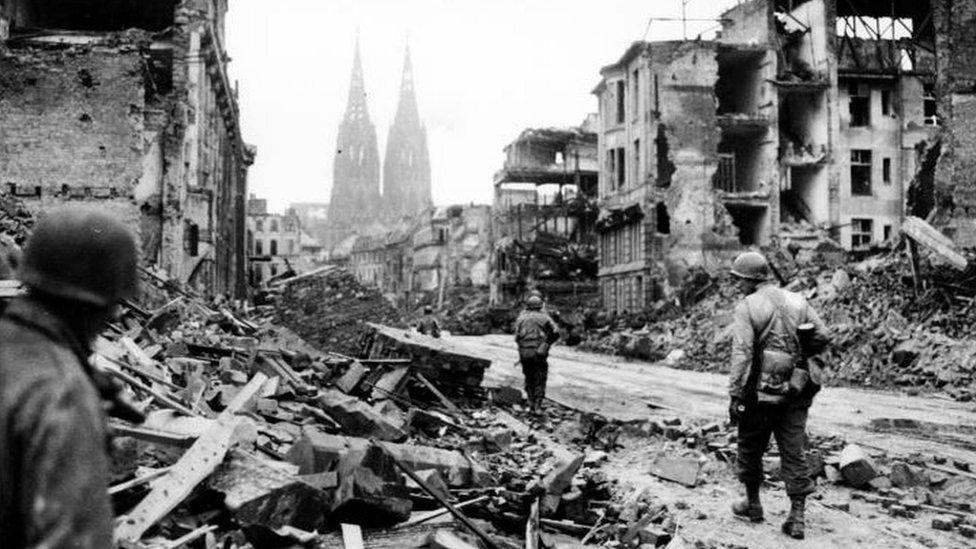 Troops of the 3rd Armored Division, U.S. First Army, advance through the devastation of Cologne, Germany, in March 1945