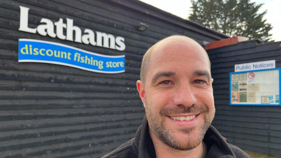 Simon Pritchard standing outside Lathams Discount Fishing store.