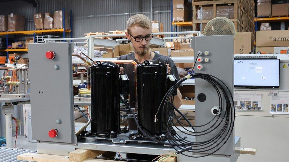 An employee works on an assembly line at the Intuis heat pump manufacturing plant in northern France on October 2, 2023.