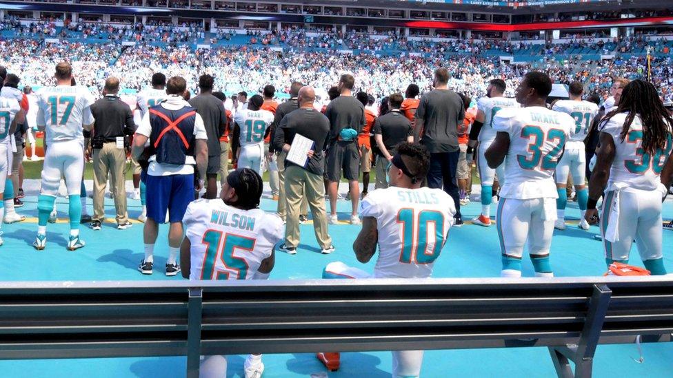 Miami Dolphins players kneeling during the national anthem