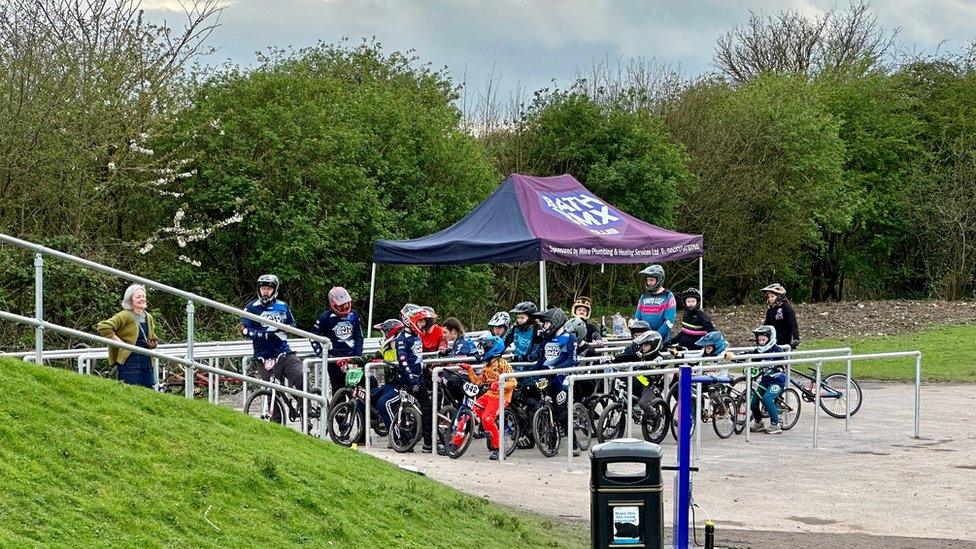 Several young BMX-ers gathered near a Bath BMX Club gazebo