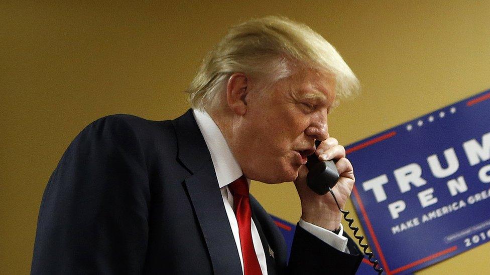 Republican presidential candidate Donald Trump speaks to a caller on the other end of the phone line as volunteers man a phone bank prior to a rally on September 12, 2016.