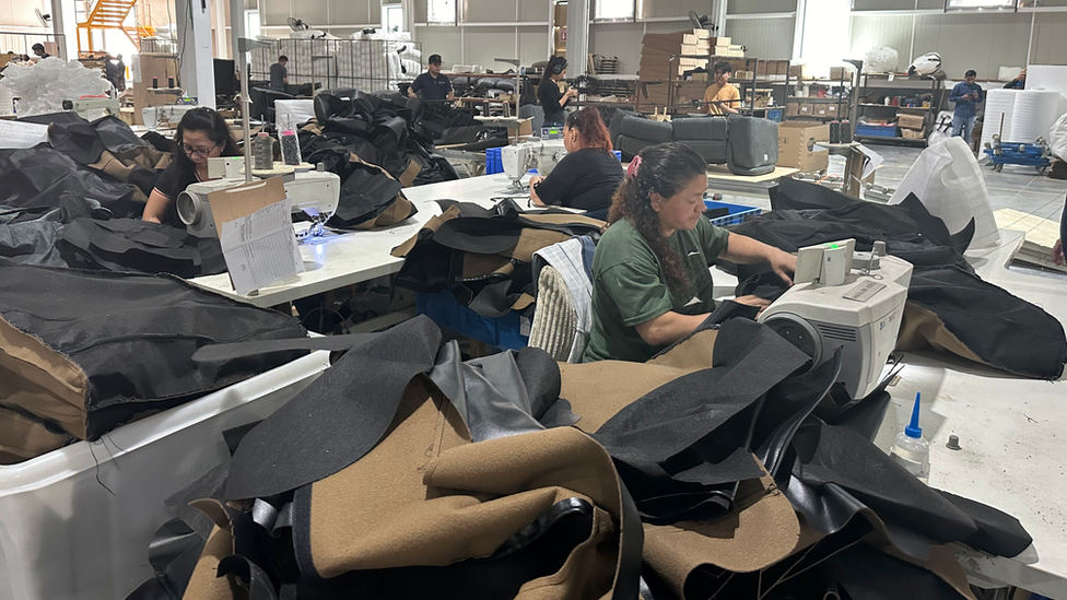 Workers at the factory sewing the covers for the sofas