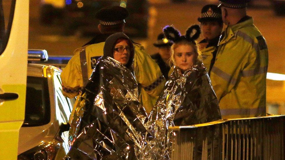 Two survivors stand with police