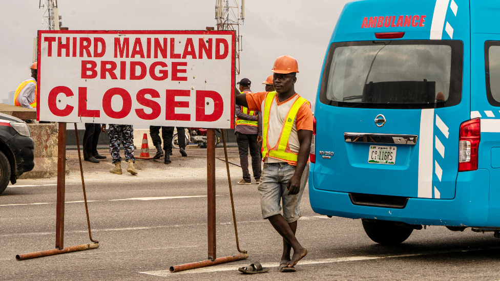 A worker and ambulance on the Third Mainland Bridge, Lagos, Nigeria