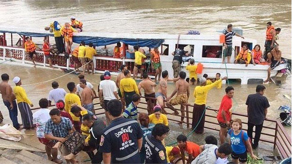 Rescuers work to save people on the stricken boat