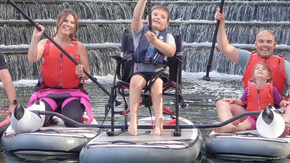 Oscar paddle boarding with his family