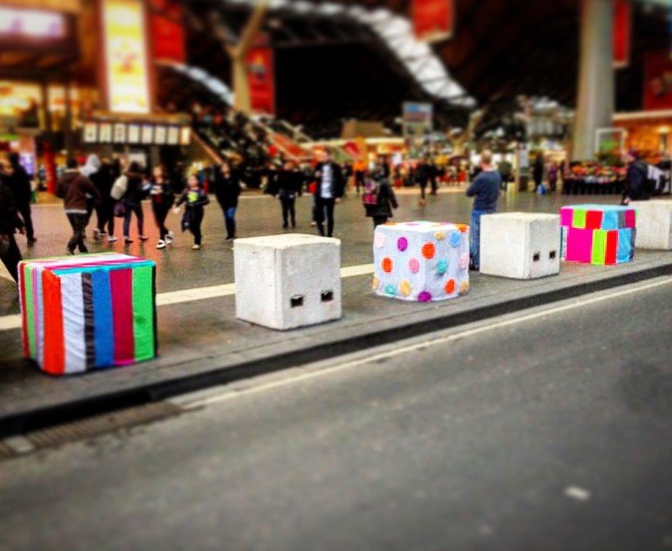 Concrete bollards covered in colourful fabric