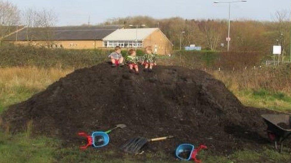 Kamran, Kaydan and Levi climb a mountain of compost at Badgers Brook