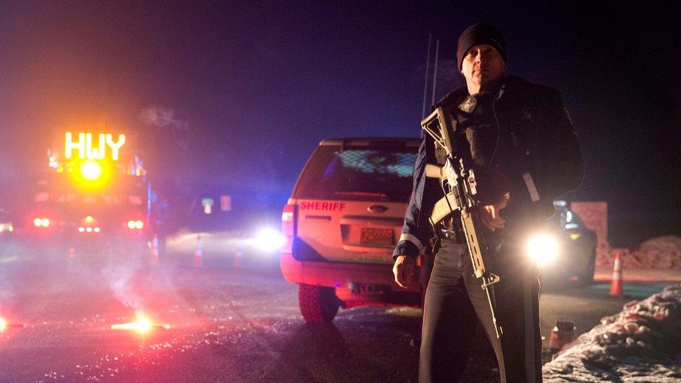 Sgt. Tom Hutchison stands in front of an Oregon State Police roadblock on Highway 395 between John Day and Burns by Oregon State police officers Tuesday, Jan. 26, 2016.