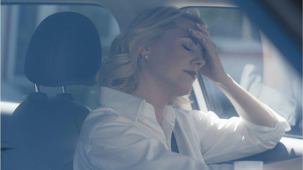 An upset woman in a car