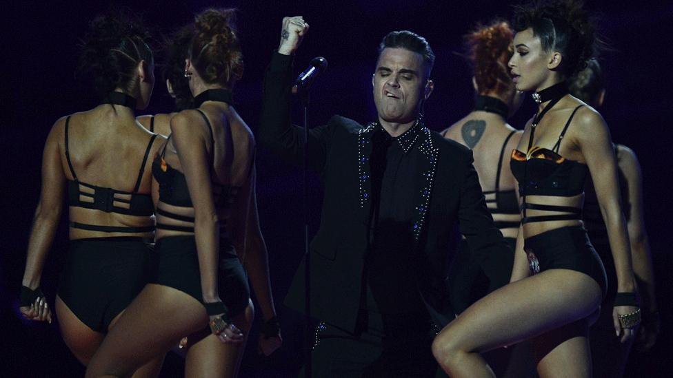 Robbie Williams and dancers on stage