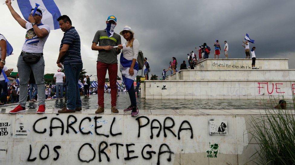 Demonstrators stand above graffiti reading "Jail for the Ortegas" in Managua on May 26, 2018