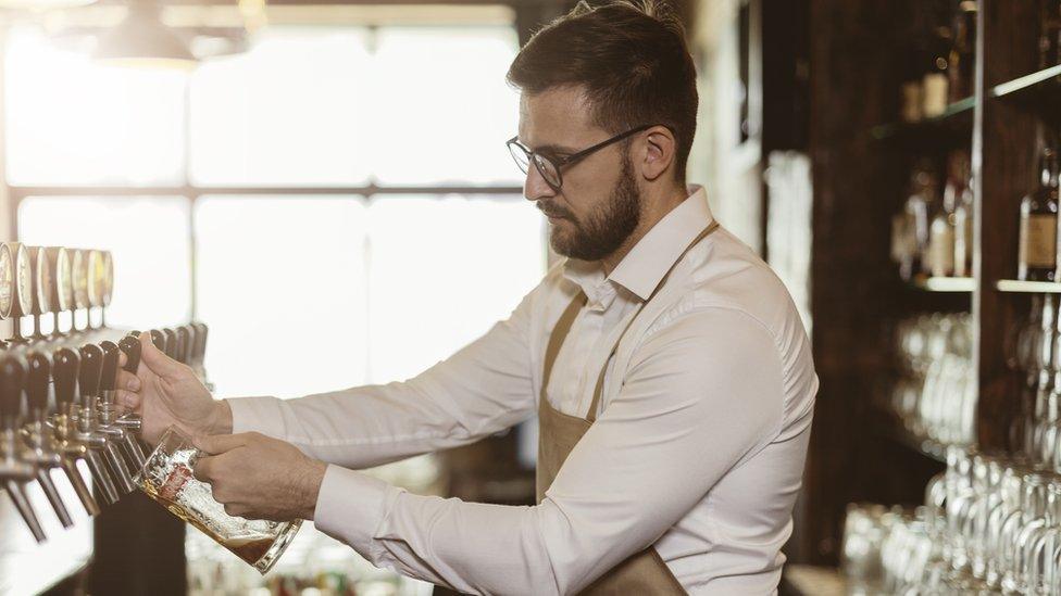 Pub worker pouring pint