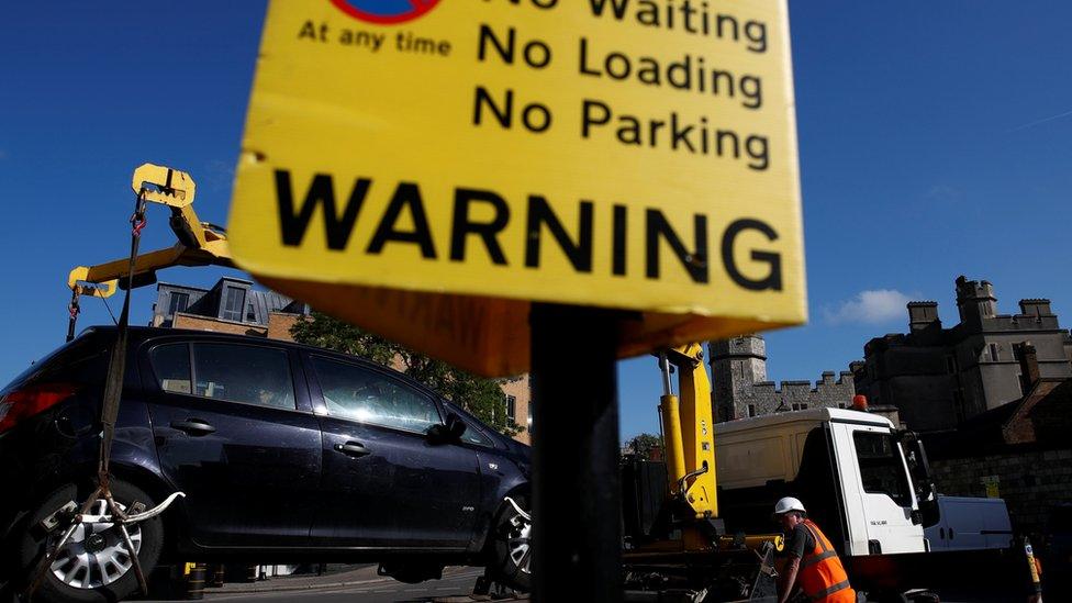 An illegally parked car is removed from a road next to Windsor Castle