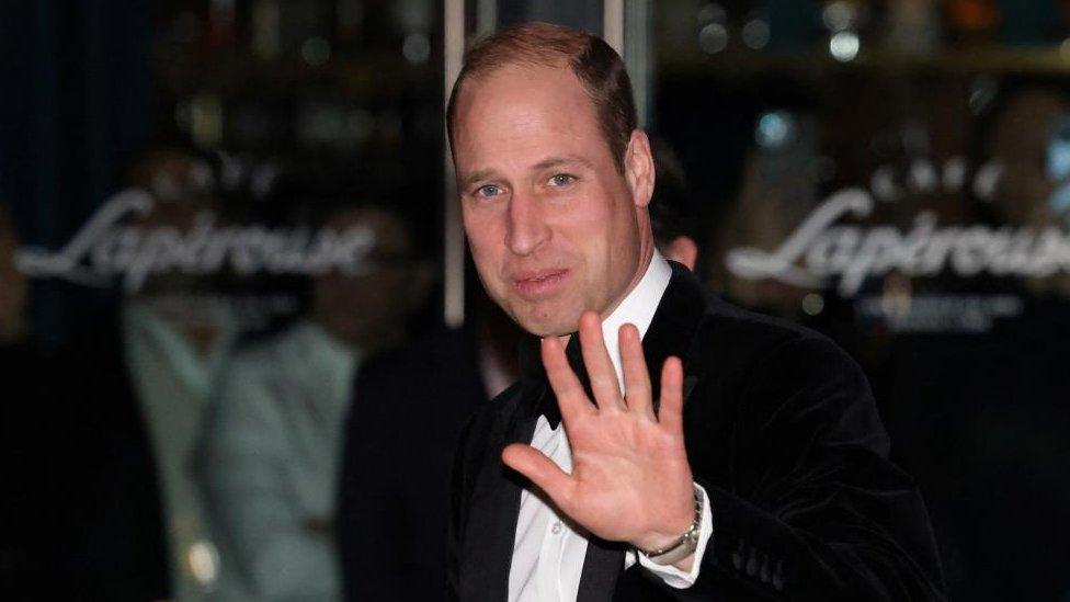 Prince William waves to a camera as he attends an event for the London Air Ambulance