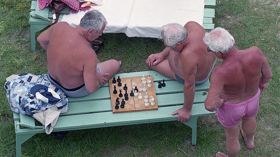 People in bathing trunks playing chess