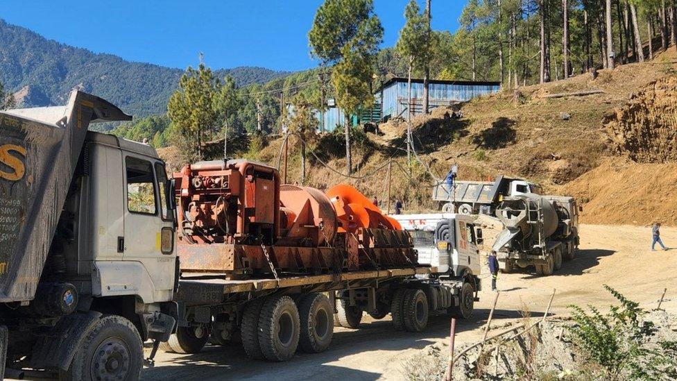 A drilling machine arrives at the site where workers are trapped in a a tunnel in Uttarkashi, 18 November