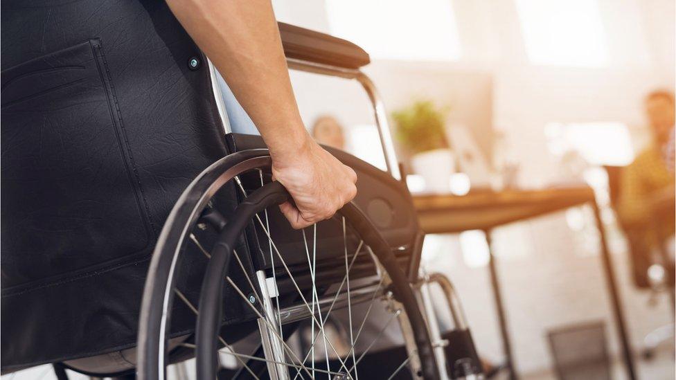 A man in a wheelchair working in an office