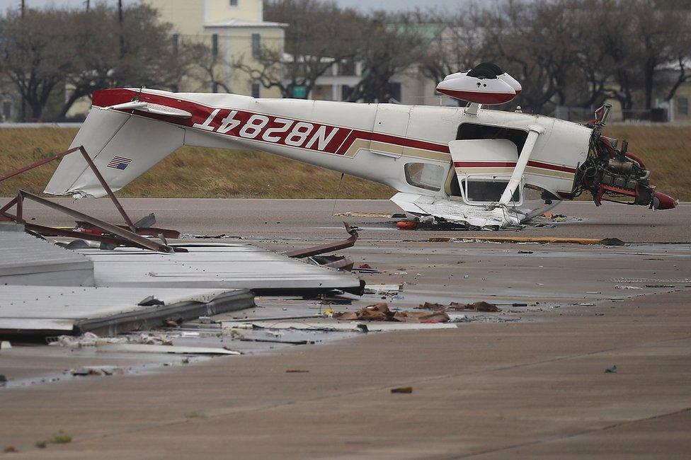 An airplane is seen flipped on its roof at Aransas County Airport after Hurricane Harvey passed through on 26 August