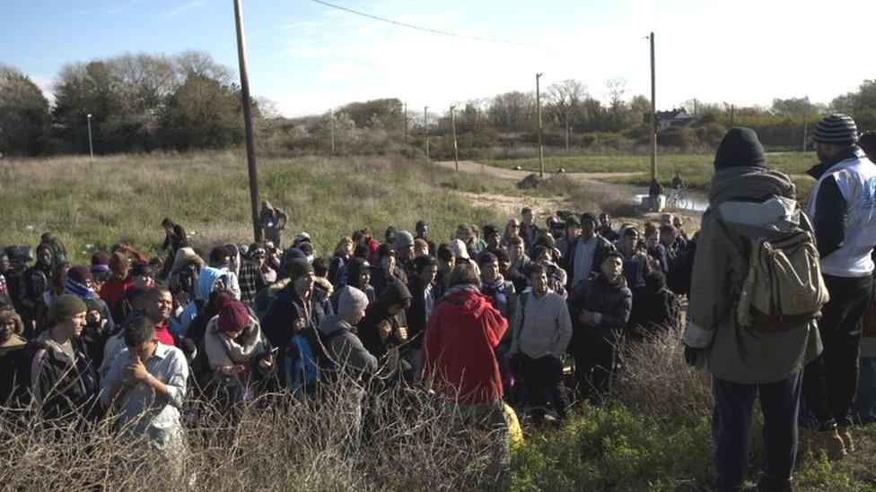 Migrants receive instructions from aid workers before getting on an official bus to take them away after being forced out from the makeshift migrant camp known as the jungle near Calais (28 October 2016)