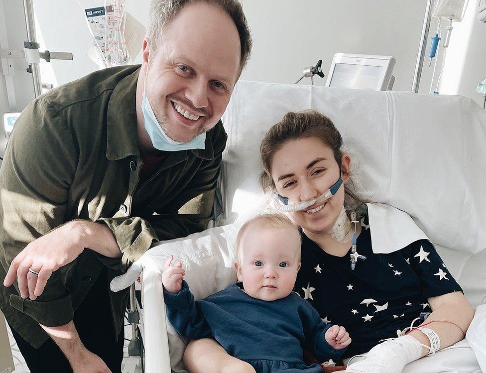 Dr Catherine McCarroll in a hospital bed after her double lung transplant with her husband and her daughter