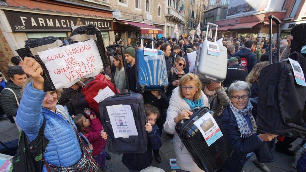 Residents of Venice hold luggages during the "Venexodus" demonstrations in Venice, Italy, 12 November 2016